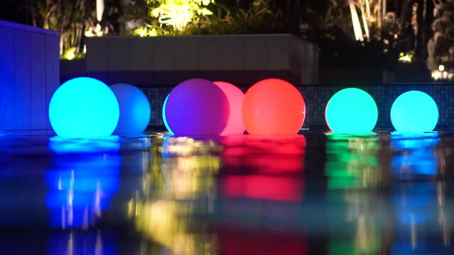 Lighting colorful balls in night pool