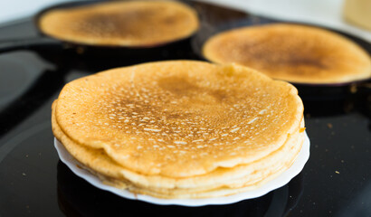 stack of appetizing flour pancakes in the kitchen during cooking