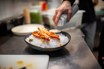 chef cooking crab legs with caviar on kitchen