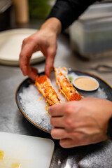 chef cooking crab legs with caviar on kitchen