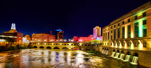Manmade waterfalls and river in Rochester New York at night with city lights