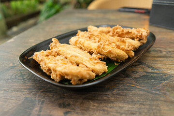 A plate of Indonesian pisang goreng tepung or fried banana snack for breakfast or hang out. Usually served with hot tea or coffee
