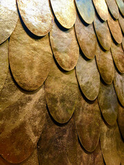 Closeup image of reflective antique surface of textured copper tile in fish scale pattern. Wall...