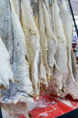 Salted dried cod bacalao on the counter of a fish store. Traditional Portuguese and Scandinavian sea fish dish