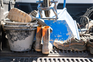 Dirty safety PPE and equipment of the construction worker which are placed on the truck of pick-up...