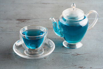  Butterfly pea tea in a glass cup and teapot on a gray background