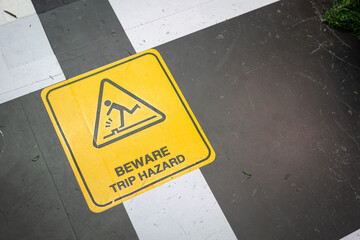 "Beware trip hazard" safety caution symbol on the ground. Sign and symbol in transportation activity object, selective focus.