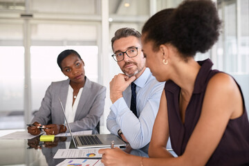 African businesswoman explaining graphs to her pensive boss