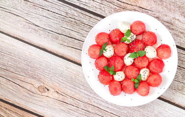 Summer fruit salad with watermelon, mozzarella cheese top view