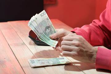counting Polish zloty cash over the table by a person
