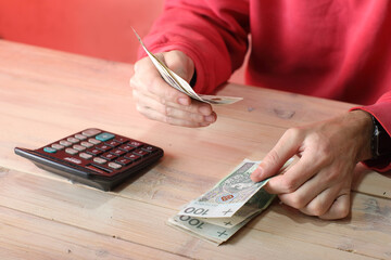 counting Polish zloty cash over the table by a person