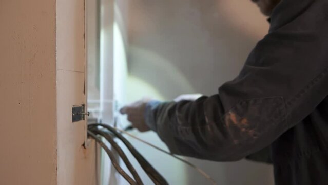 An electrician installs a switchboard in a new building.