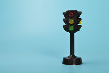 Traffic light toy isolated on a blue background. Copy space for the text.