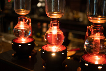 Close-up at the flask glassware with liquid chemical is heating on the magnetic kettle. Science...