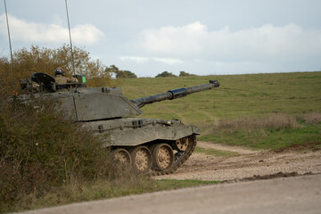 a British army FV4034 Challenger 2 ii main battle tank breaks cover on a military combat exercise, Wiltshire UK