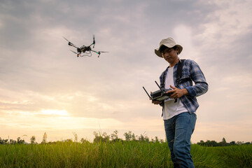Agricultural specialist controls agriculture drone with remote controller for spraying fertilizer...
