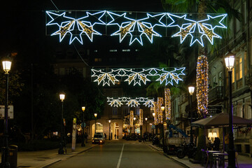 Fototapeta na wymiar Vigo, Spain - December 05, 2022: Christmas lights decoration, with tourists walking through its streets in the city of Vigo, Pontevedra, Spain