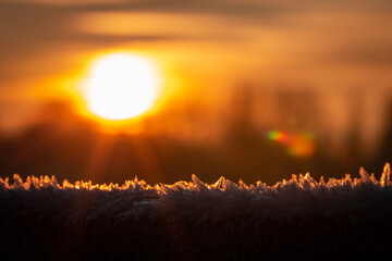 close up macro shot using selective focus bokeh of frost crystals with the sunrise behind...