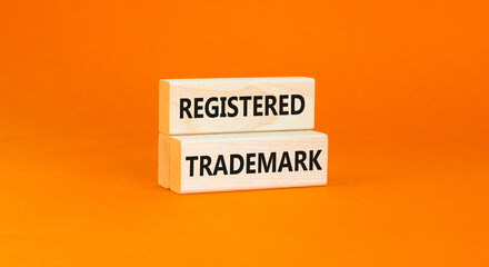 Registered trademark symbol. Concept word Registered trademark on wooden blocks. Beautiful orange table orange background. Business and registered trademark concept. Copy space.