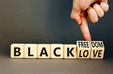 Black freedom and love symbol. Concept words Black freedom Black love on wooden cubes. Businessman hand. Beautiful grey table grey background. Black freedom and love concept. Copy space.