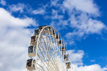 Ferris wheel on the background of the sky and clouds