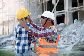 A father takes care of his son happily on a construction site.