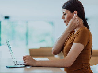 Obraz premium Woman sitting in living room using laptop look at cam talk by video call with business friend relatives, head shot. Job interview answering questions.