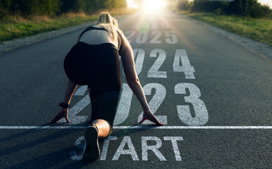 Woman stands at the start line and gives a new start to 2023. New goals, plans, actions and...