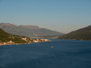 Obraz premium Landscape bay with yachts and boats surrounded by green mountains under blue sky