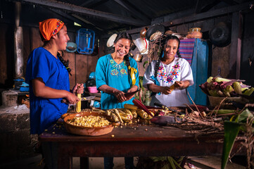 Retrato de Mujeres pelando y cortando elotes frescos para cocinar en una cocina antigua con estufa...
