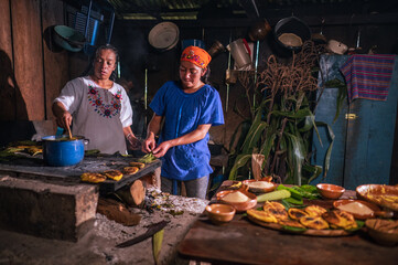 Mujeres cocinando en una cocina antigua y con una cocina de leña.