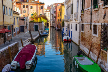 Venice, its characteristic architecture. View of an internal canal, with the docking of boats moored to the typical "paline".