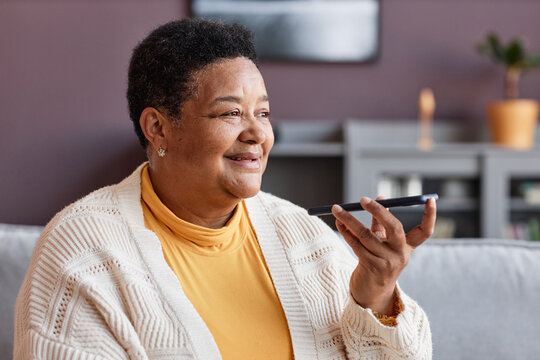 Portrait Of Black Senior Woman Recording Voice Message Via Smartphone In Home Setting