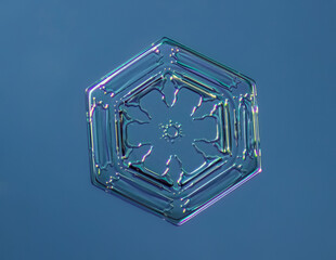 Snowflake on smooth gradient background. Macro photo of real snow crystal on glass surface. This is...