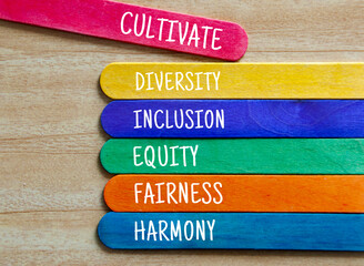 Cultivate diversity, inclusion, equality, fairness and harmony text on colorful wooden stick....