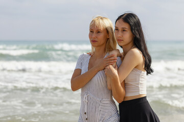 Portrait of mother and daughter against the background of the sea, friendship, family leisure