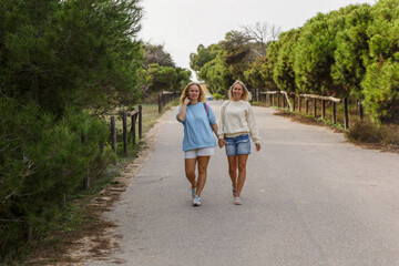 Fototapeta na wymiar Two female friends walk in the park, girlfriends vacation together