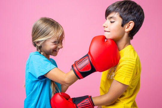 Two playful kids boxing with red gloves