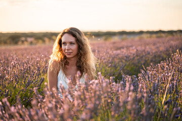 Fototapeta na wymiar Woman in a lavender field during sunset