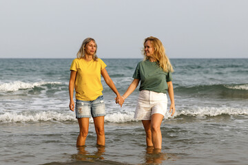 Girlfriends walk and have fun at the sea, family vacation at sea