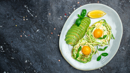 Plate with a keto diet food. paleo keto breakfast fried eggs, zucchini and avocado. Keto, paleo breakfast. Top view, copy space