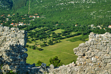 view through a hole in an ancient wall on a mountain