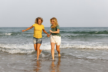 Girlfriends walk and have fun at the sea, family vacation at sea