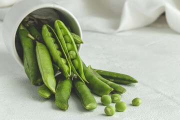 Raw green pea pods on light background