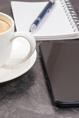Smartphone, coffee with milk and notepad for notes. Work or relaxation with mobile phone