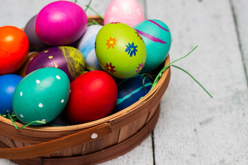 Fototapeta na wymiar Basket with painted colorful easter eggs