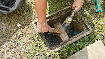 Cleaning the grease trap by scrub with a steel wire brush, some soap and water. - obrazy, fototapety, plakaty