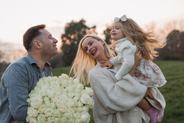 father congratulate mother with dauther and give flowers