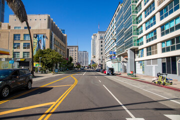 an intersection on Grand Ave with traffic signals, cars and trucks driving on the street surrounded...