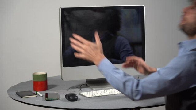 Businessman punches computer and keyboard that doesn't work - problems at work in office and smart working - hysterics against internet and modern technology, online addiction- virus and hackers 